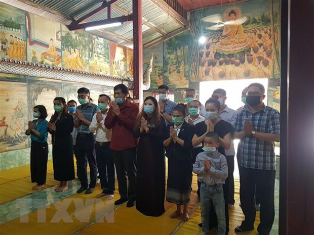 Offering incense to commemorate heroes and martyrs in Luang Prabang